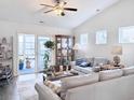 Bright living room features vaulted ceilings, comfortable seating, and sliding glass doors leading to outdoor space at 1856 Melville Ct., Little River, SC 29566