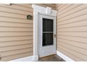Unit 104 entrance showing door with decorative moulding and a green address plate at 2000 Cross Gate Blvd. # 104, Surfside Beach, SC 29575