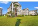 A well-maintained condo building with a sprawling green lawn and mature landscaping at 2000 Cross Gate Blvd. # 104, Surfside Beach, SC 29575