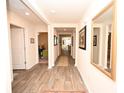 Inviting hallway featuring wood-look flooring and neutral paint, leading to other rooms in the house at 203 Golden Bear Circle, Longs, SC 29568