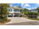 View of the exterior of the coastal home with elevated construction, spacious parking, and a welcoming front porch at 2602 Holly Dr., North Myrtle Beach, SC 29582