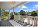 A tranquil porch setting with a wooden deck, white railing, ceiling fan, and neighborhood views at 2602 Holly Dr., North Myrtle Beach, SC 29582