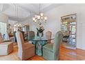 Elegant dining room with a glass table, upholstered chairs, mirrored walls, and wood flooring at 321 Heather Ct., Sunset Beach, NC 28468