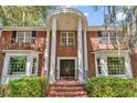 Close-up of the home's entrance with white columns and a brick facade plus a charming doorway at 356 Chapman Loop, Pawleys Island, SC 29585