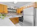 Well-lit kitchen featuring stainless appliances, wood cabinets, mosaic backsplash, and modern countertops at 3700 Golf Colony Lane # 18-G, Little River, SC 29566