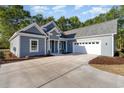 Stunning exterior view of a single-story home featuring a concrete driveway and manicured landscaping at 4022 Macks Rd, Aynor, SC 29511