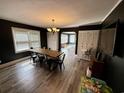 Bright dining room featuring a rustic wood table, laminate flooring, stylish light fixture, and view into another room at 408 South Farr Ave., Andrews, SC 29510