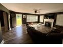 Spacious living room with fireplace, ceiling fan, large windows, gray walls and wood-look flooring, complete with a comfy brown sofa at 408 South Farr Ave., Andrews, SC 29510
