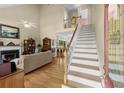 Spacious home foyer with hardwood floors, a staircase, and a glimpse into the living and dining areas at 414 Staghorn Ln., Longs, SC 29568