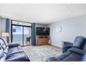 Cozy living room with hardwood floors, balcony access, and beautiful ocean views at 4311 S Ocean Blvd. # 701, North Myrtle Beach, SC 29582