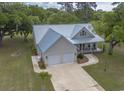 Stunning aerial view of home, featuring a metal roof, two-car garage, and a sprawling driveway on a lush lot at 521 Oak Lawn Rd., Georgetown, SC 29440