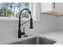 Modern kitchen sink features a sleek matte black faucet and stylish white countertops at 6001 S Kings Hwy., Myrtle Beach, SC 29575