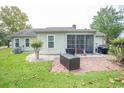 Spacious backyard featuring a brick patio, lush lawn, and mature trees, ideal for outdoor living at 654 Blue Bird Ln., Murrells Inlet, SC 29576