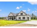 Beautiful one-story home with a modern design, black trim, and concrete driveway at 7103 Louisville Rd., Aynor, SC 29511