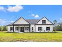 Charming single-story home featuring black trim, white siding, and a well-maintained lawn at 7103 Louisville Rd., Aynor, SC 29511