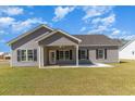 The backyard features a covered patio, a well-maintained lawn, and gray exterior with black window shutters at 108 Old Chimney Ln, Conway, SC 29526
