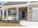 Inviting front porch with columns and landscaping, leading to a black front door with address at 108 Old Chimney Ln, Conway, SC 29526