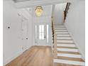 Spacious foyer featuring hardwood floors, staircase, and a modern chandelier, creating a bright and inviting entrance at 1219 Bentcreek Ln., Myrtle Beach, SC 29579