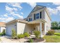 Inviting two-story home boasting a cozy front porch, lush landscaping, and a well-manicured lawn at 1313 Cascarilla Ct., Myrtle Beach, SC 29579