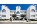 Elegant white condo building with symmetrical design, featuring arched windows and private balconies at 1533 Lanterns Rest Rd. # 304, Myrtle Beach, SC 29579