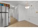 Dining area featuring tile flooring, a modern chandelier and stainless steel refrigerator at 1851 Colony Dr. # 4-F, Surfside Beach, SC 29575