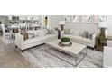 Bright living room with neutral furniture, modern decor, and open to kitchen area for easy living and entertaining at 2508 Watershed Way, Longs, SC 29568