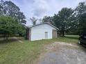 Back exterior view of the home, with vinyl siding, brick accents, and a gravel parking area at 2560 Wise Rd., Conway, SC 29526