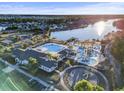 An aerial view of a large community pool, a kiddie pool and a play ground next to a lake at 3053 Chesterwood Ct., Myrtle Beach, SC 29579