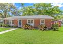 Charming brick home with green lawn and trimmed shrubs at 311 Surfside Dr., Surfside Beach, SC 29575