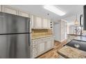 Bright kitchen with stainless steel refrigerator, granite countertops, and white cabinetry at 4601 N Ocean Blvd. # 105, North Myrtle Beach, SC 29582
