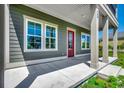 Inviting front porch showcasing a red door, classic columns, and a well-maintained concrete surface at 468 Saint Julian Ln., Myrtle Beach, SC 29579
