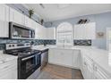 Bright kitchen featuring white cabinets, stainless steel appliances, tile backsplash, and a large arched window at 4787 Wild Iris Dr. # 101, Myrtle Beach, SC 29577