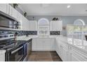 Bright kitchen featuring white cabinets, stainless steel appliances, tile backsplash, and a large arched window at 4787 Wild Iris Dr. # 101, Myrtle Beach, SC 29577
