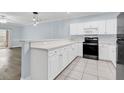 Kitchen with white cabinets and appliances, gray countertops, and tile floor at 4878 Dahlia Ct. # 104, Myrtle Beach, SC 29577