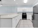 Kitchen with white cabinets and appliances, gray countertops, and tile floor at 4878 Dahlia Ct. # 104, Myrtle Beach, SC 29577