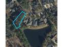 Aerial view of a property surrounded by mature trees and a tranquil pond at 4932 South Island Dr., North Myrtle Beach, SC 29582