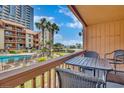Relaxing balcony view overlooking a pool, manicured lawn, and ocean in the distance at 5507 N Ocean Blvd. # 105, Myrtle Beach, SC 29577