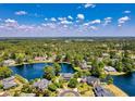 Expansive aerial view showcasing a residential community nestled around a picturesque lake, surrounded by lush trees and clear blue skies at 8231 Forest Lake Dr., Conway, SC 29526
