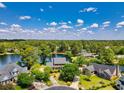 Aerial view of a luxurious lakeside community with beautiful homes, lush greenery, and serene water views on a sunny day at 8231 Forest Lake Dr., Conway, SC 29526