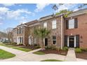 Brick townhomes with black shutters, landscaped yards, sidewalks, and beautiful curb appeal at 830 Howard Ave. # D, Myrtle Beach, SC 29577