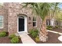 Attractive brick townhome exterior with mature landscaping and an inviting black front door at 830 Howard Ave. # D, Myrtle Beach, SC 29577