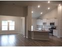 Spacious living area adjacent to a modern kitchen with stainless appliances and a view to the backyard at 8718 Baton Rouge Ave Nw, Calabash, NC 28467