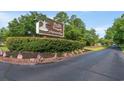 Community entrance sign with manicured landscaping and American flags welcoming residents at 976 South Marlin Circle, Murrells Inlet, SC 29576