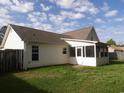 Home back view highlighting the vinyl siding, screened-in porch and fenced backyard at 108 Pickerel Blvd., Longs, SC 29568