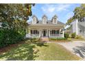 Inviting home boasts a spacious front yard, attractive dormer windows, and a charming porch at 119 Berry Tree Dr., Pawleys Island, SC 29585