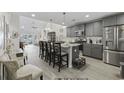 Charming kitchen with gray cabinets, granite countertops, island seating, and views of the spacious living area at 136 Queens Cove Place # B, Myrtle Beach, SC 29579