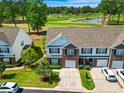 Aerial view of townhome with golf course view, manicured lawns, mature trees and adjacent pond at 220 Connemara Dr. # A, Myrtle Beach, SC 29579