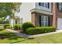 Charming brick and vinyl-sided townhome with manicured landscaping, walkway, and black shutters at 220 Connemara Dr. # A, Myrtle Beach, SC 29579