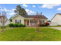 Inviting single-story home featuring a well-kept lawn and charming front garden at 2446 Farmwood Circle, Conway, SC 29527