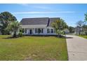 Beautifully landscaped front yard with lush green grass and mature palm trees at 2703 Canvasback Trail, Myrtle Beach, SC 29588